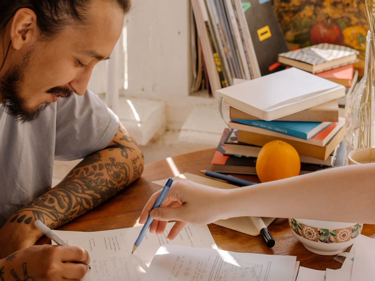Zwei Studierende arbeiten gemeinsam an Prüfungsunterlagen